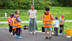 Mitarbeiterin des Energiebergs erklärt Kindern den Müllsammel-Parcours