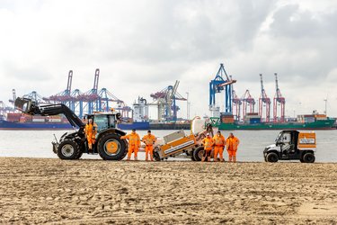 Fahrzeuge zur Elbstrandreinigung mit TeamOrange mit Elbe und Hafen im Hintergrund