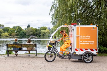 Lastenrad in der Grünanlage mit einem Kollegen