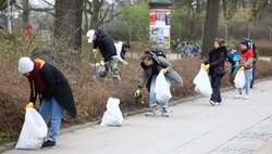 Gruppe Erwachsener sammelt Müll und füllt ihn in Beutel